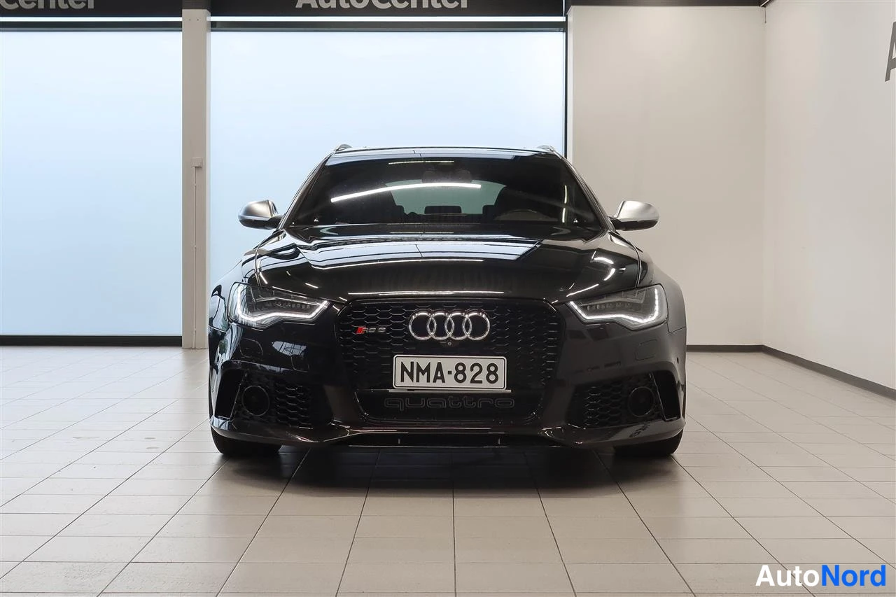 Edestä: Mustan farmariauton etunäkymä AutoCenter-hallissa, rekisteritunnus.
