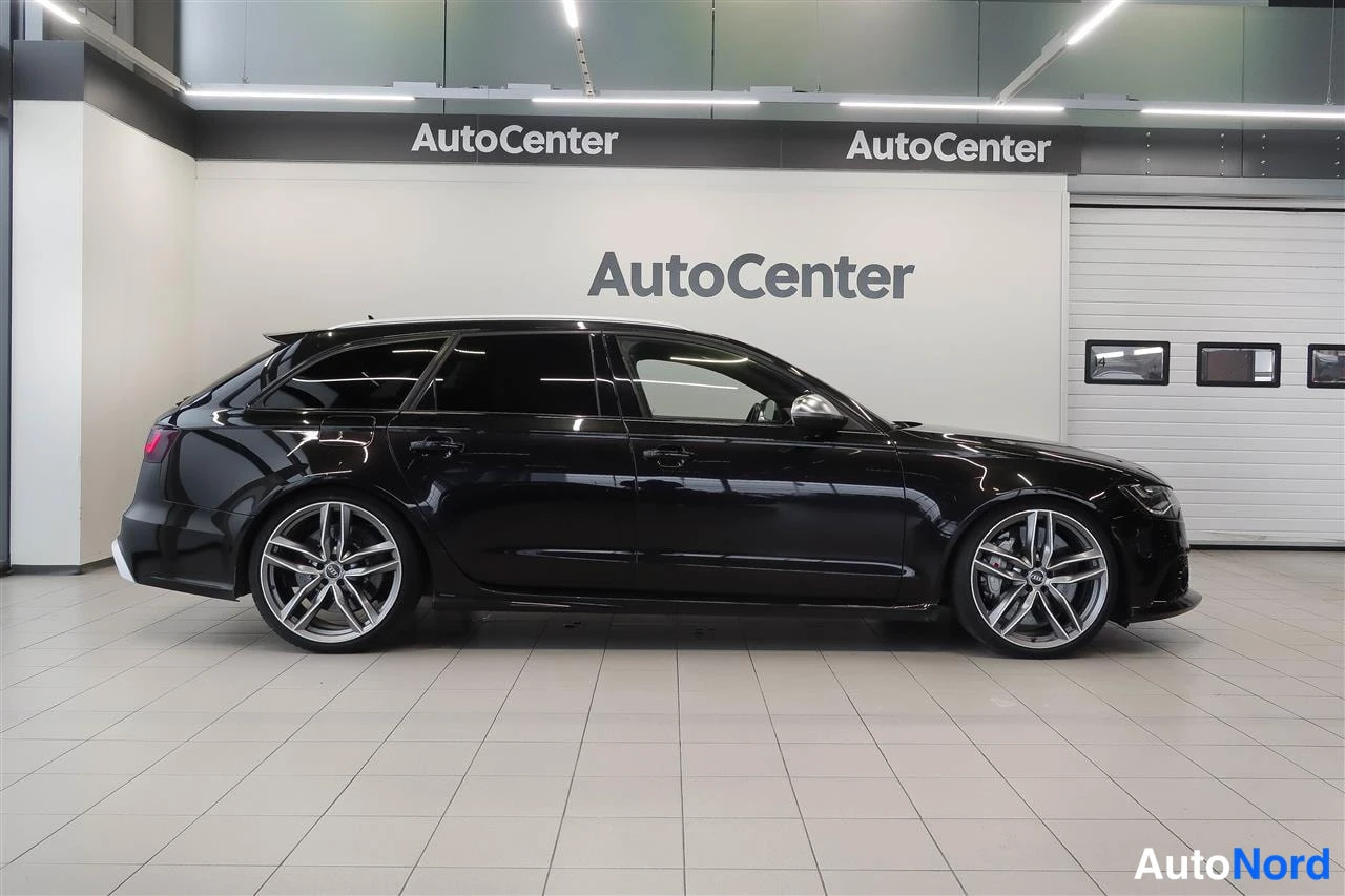 Sivulta: Mustan farmariauton sivunäkymä AutoCenter-hallissa, oikea kylki näkyvissä.