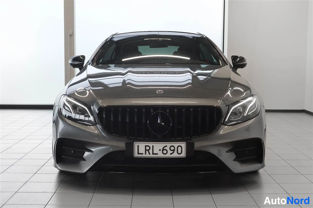 Edestä: Mercedes-Benz E 53 AMG edestäpäin, harmaa kori ja musta panssariritilä, rekisterikilpi.