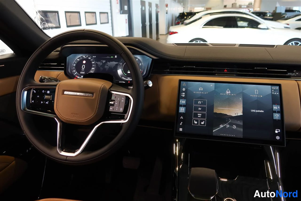 Asiakirja: LAND ROVER -mittarissa ohjauspyörä, digitaalinen instrumenttinäyttö ja vaakasuuntainen kosketusnäyttö, jossa NAVIGOINTI ja PUHELIN-valikot.