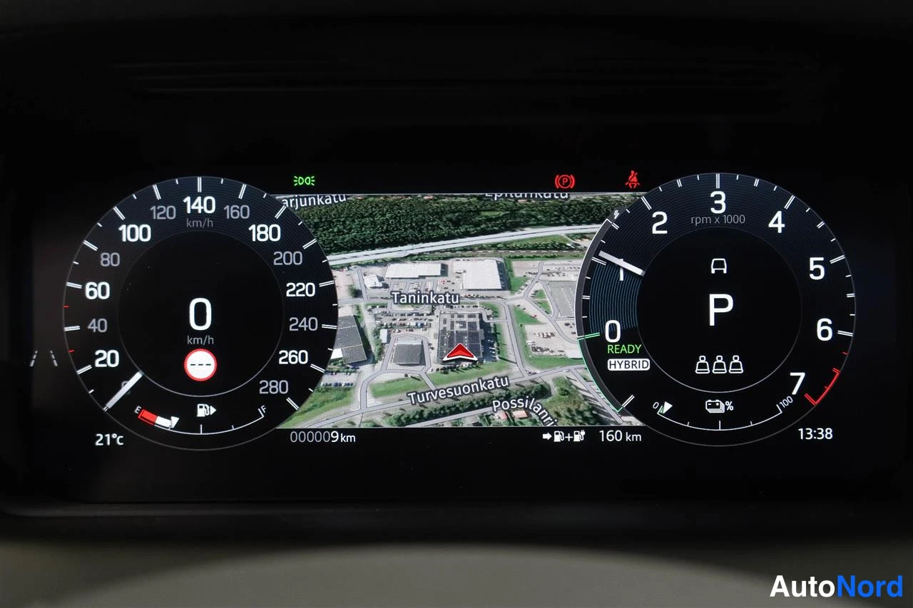 Edestä: Digitaalinen mittaristo: nopeusmittari näyttää 0 km/h, matkan mittari 000009 km, vaihde P ja teksti READY HYBRID, lisäksi kartta- ja lämpötilatiedot (21°C).