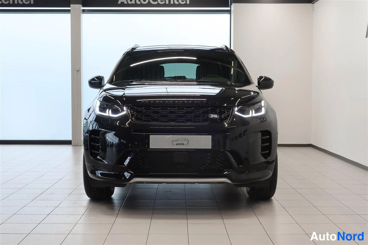 Edestä: Musta Land Rover Discovery Sport suoraan edestä, etusäleikkö ja LED-ajovalot