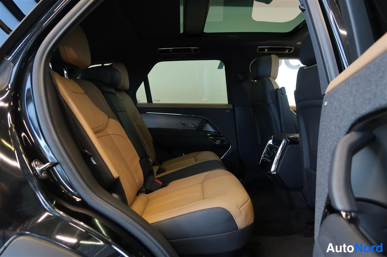 Muu: Takaistuin beige-mustalla nahkaverhoilulla ja panoraamakatto näkyy yläpuolella; keskinen konsoli ja taustapenkki takaa katsottuna.