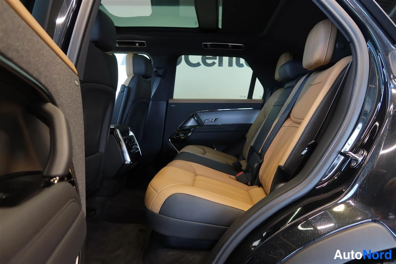 Muu: Takaistuimet autosta kuvattuna: beige-mustat nahkapenkit ja panoraamakaton reunaa.