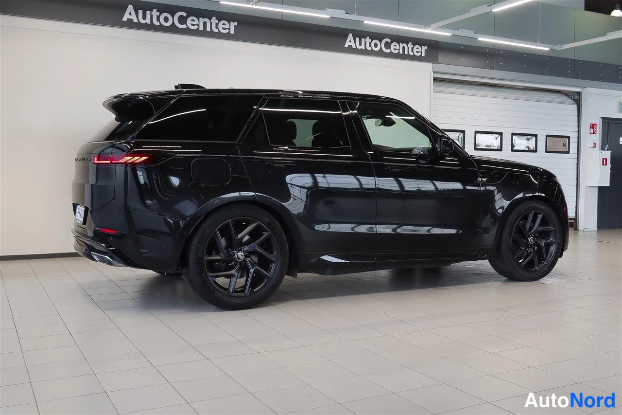 Takaviisto: Mustan Range Rover Sportin takakulmanewsigt näkyy oikea sivu ja takapää, mustat vanteet, AutoCenter-hallissa