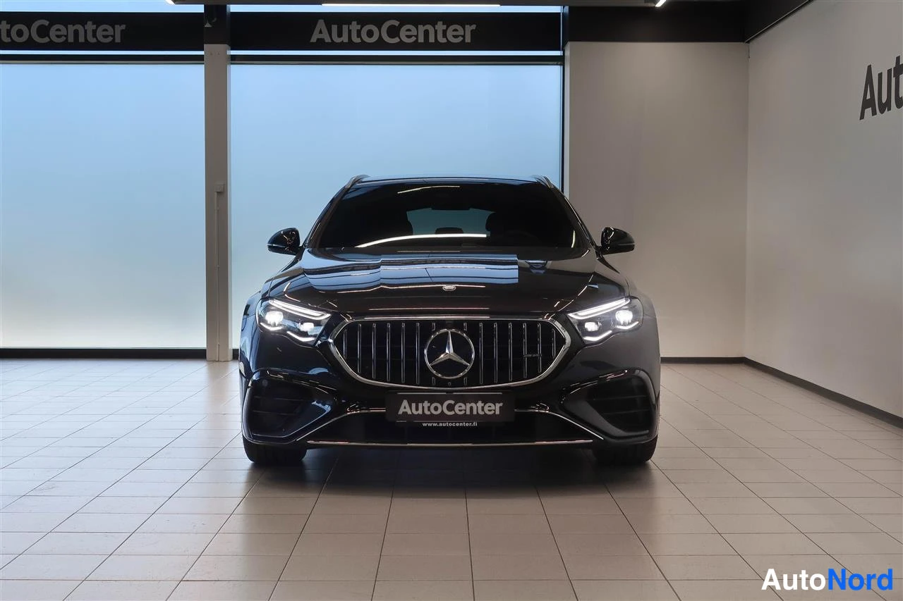 Edestä: Mustan Mercedes-Benzin etunäkymä, LED-ajovalot päällä, AutoCenter-tunnus etupuskurissa.