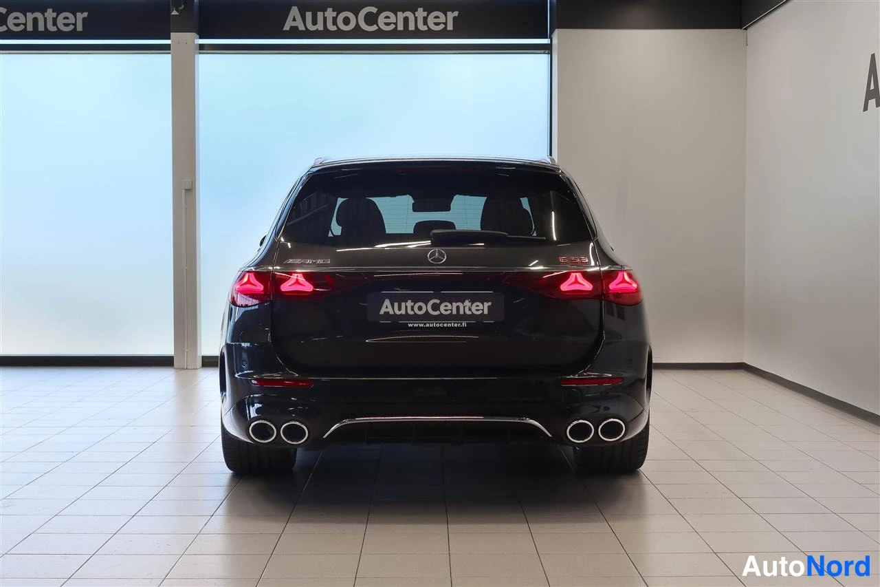 Takaa: Mercedes-Benz E 53 -farmarin takaosa rekisterikilven paikalla AutoCenter-tekstillä, punaiset takavalot ja neljä pyöreää pakoputkea.