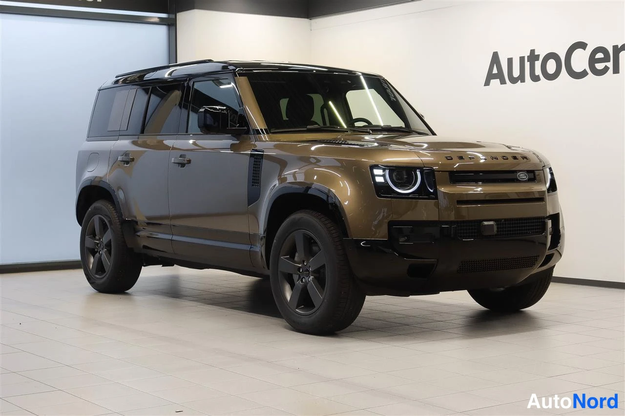 Etuviisto, nokka oikealle: Land Rover Defender, ruskeansävyinen, etukulmanäkymä sisätiloissa