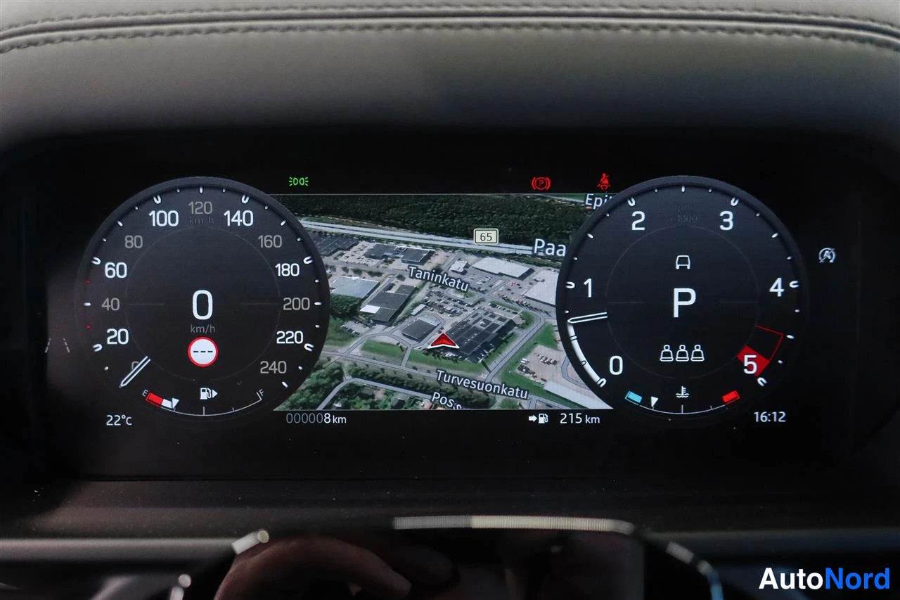 Muu: Digitaalisen mittariston lähikuva: nopeusmittari 0 km/h, vaihde P, 3D-navigaatiokartta, kokonaislukema 000008 km, jaksollinen kulutus 215 km ja ulkolämpötila 22
