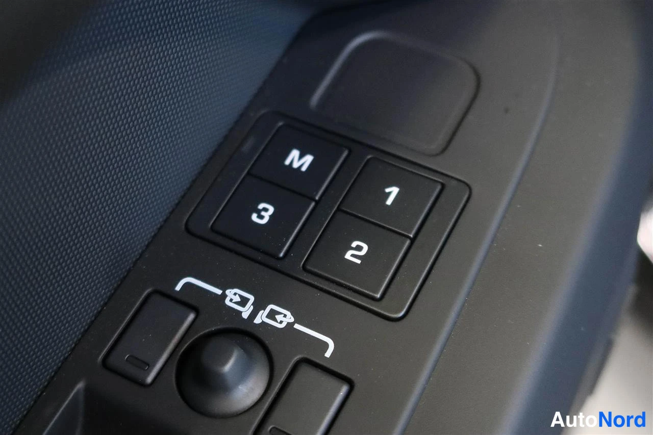 Muu: Värikkään lähikuva auton oven sisäpaneelin napeista: istuinmuistiaippaat M, 1, 2 ja 3, peilien säätökytkimet ja joystick-kytkin.