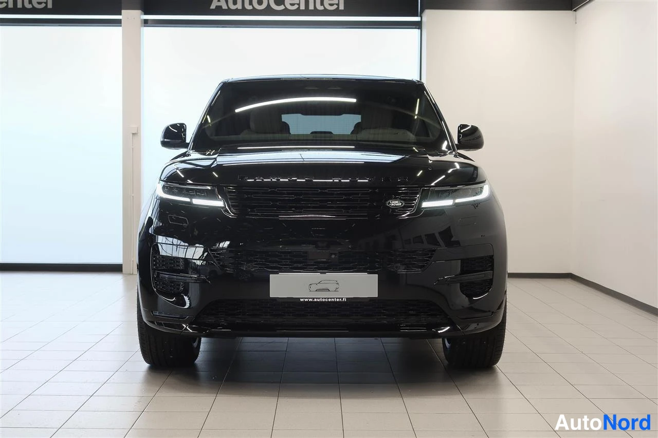 Edestä: Mustan Range Rover Sport -maasturin etunäkymä suoraan edestä, LED-ajovalot päällä.