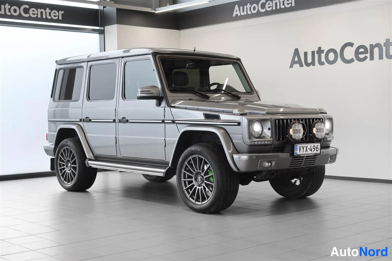 Etuviisto, nokka oikealle: Mercedes-Benz G Hopeaharmaa etuosa vasemmasta kolmanneksesta, koko kylki ja katolla telineet näkyvissä.