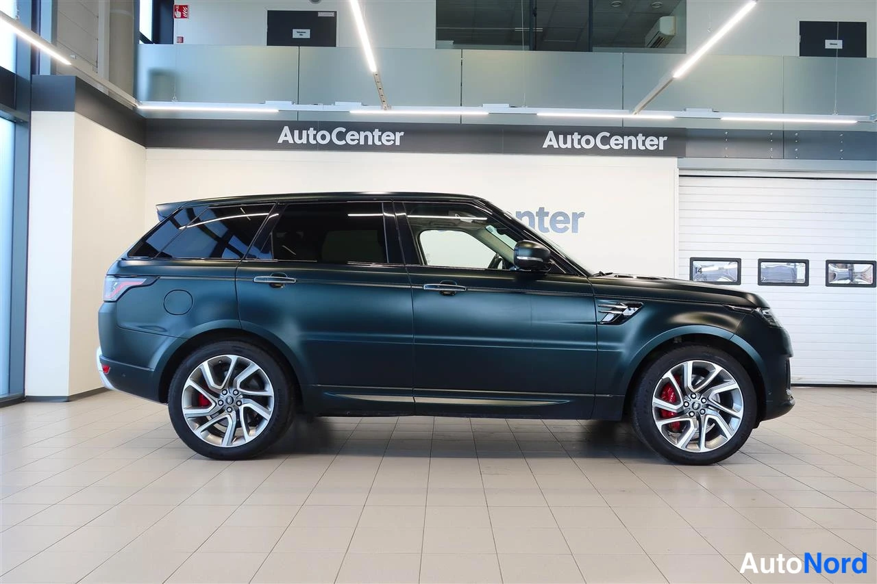 Takaviisto: Tummanvihreä Range Rover Sport -tyylinen maasturin sivukulma-autosali, kevytmetallivanteet ja punaiset jarrusatulat näkyvissä.