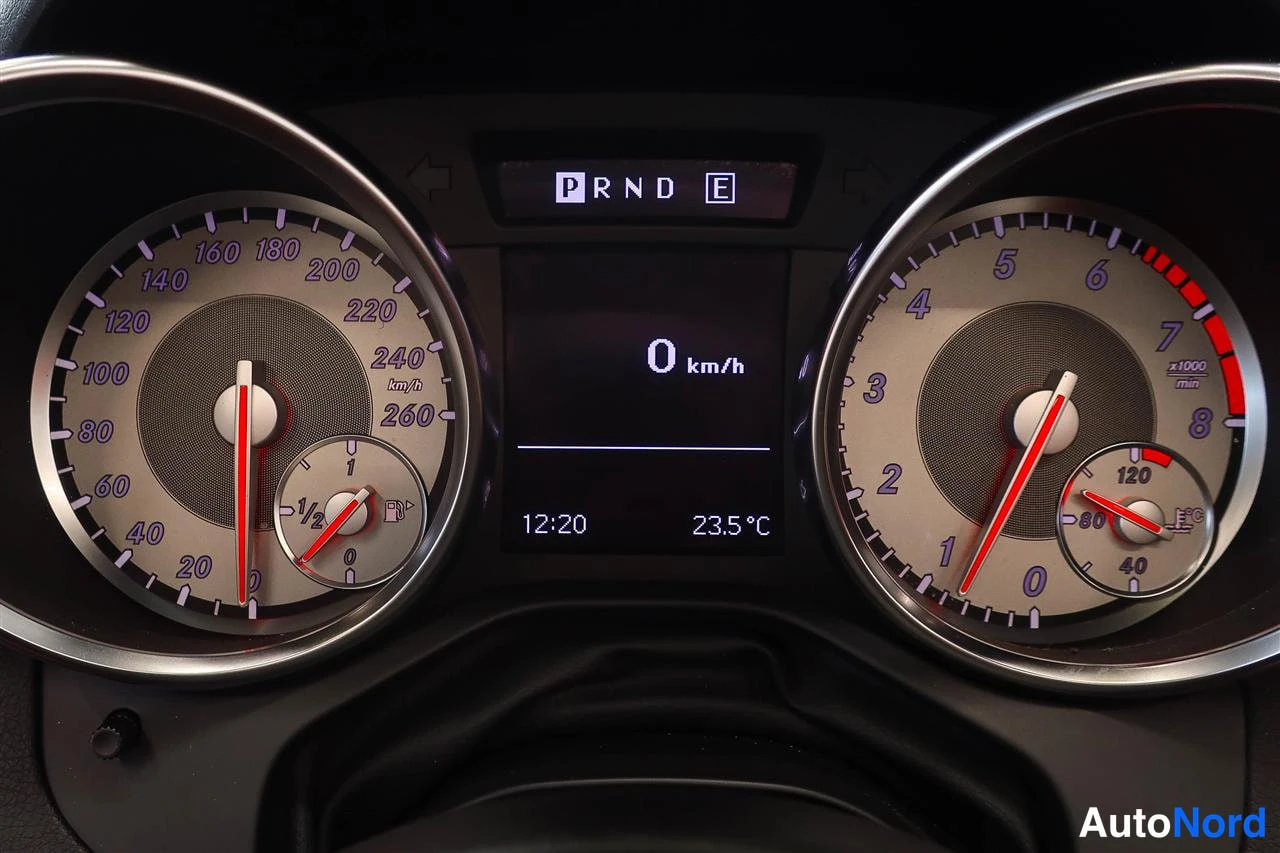 Muu: Mittariston lähikuva: nopeusmittari 0–260 km/h, kierroslukumittari ja näyttö jossa P RND E, '0 km/h', kello 12:20 ja lämpötila 23,5 °C.