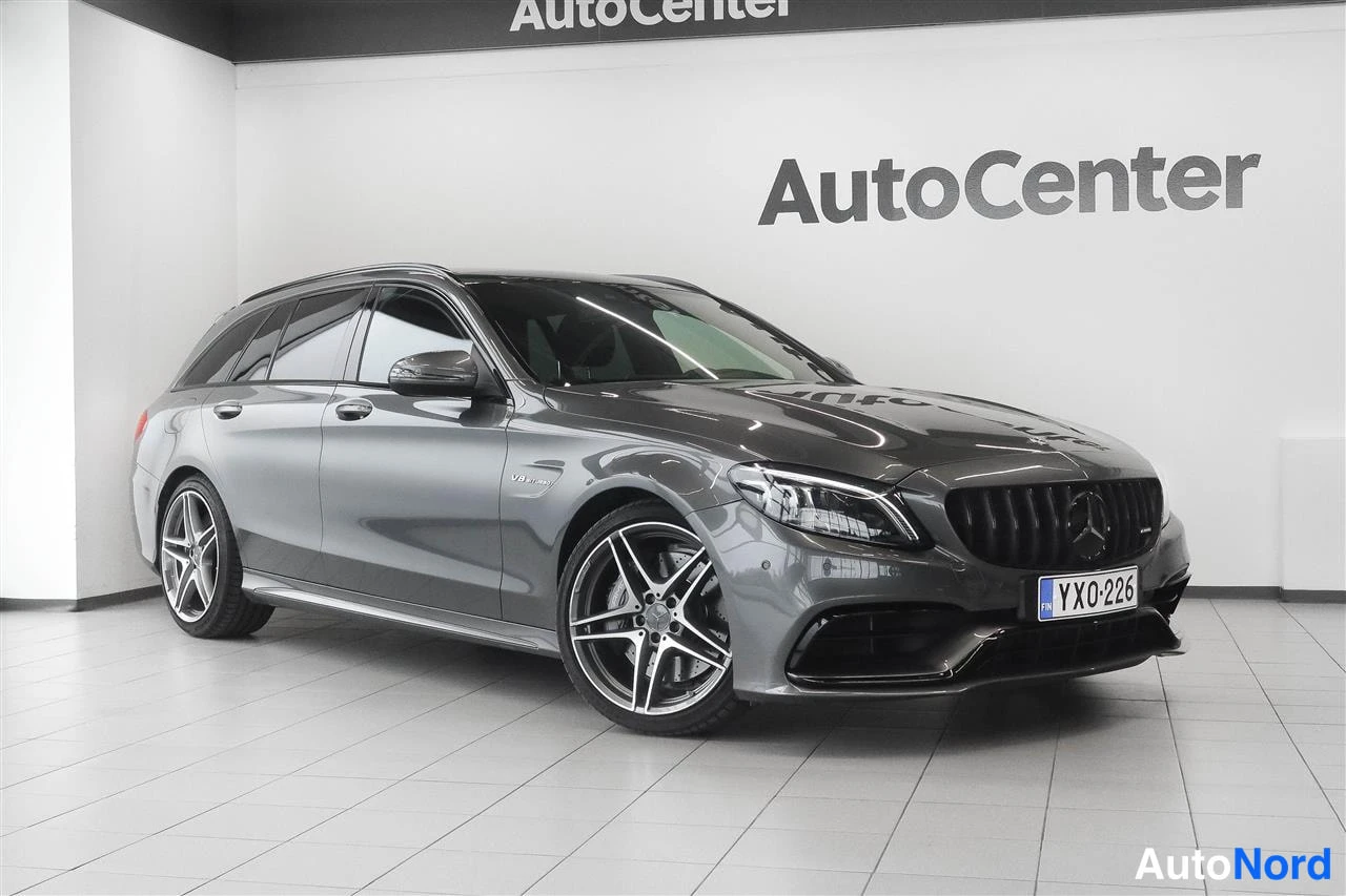 Etuviisto, nokka oikealle: Tummanharmaa Mercedes-Benz farmari näkyvässä kolmeneljännes-etukuvassa oikealta, AutoCenter-tilassa, rekisteritunnus.
