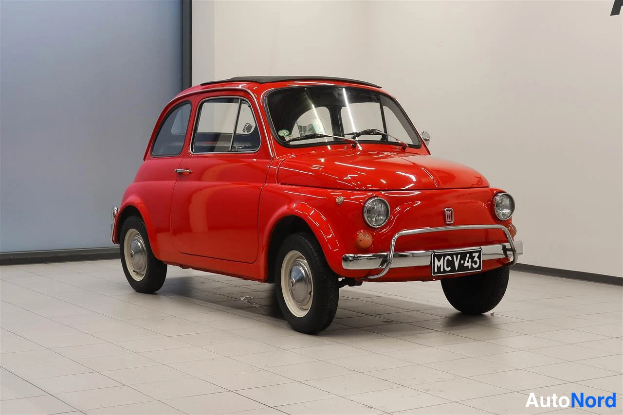 Etuviisto, nokka oikealle: Punainen Fiat 500L etuviistosta, kromipuskurit ja rekisterikilpi.