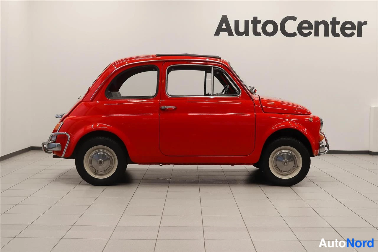 Sivulta: Punaisen Fiat 500L:n sivunäkymä oikealta studiossa.