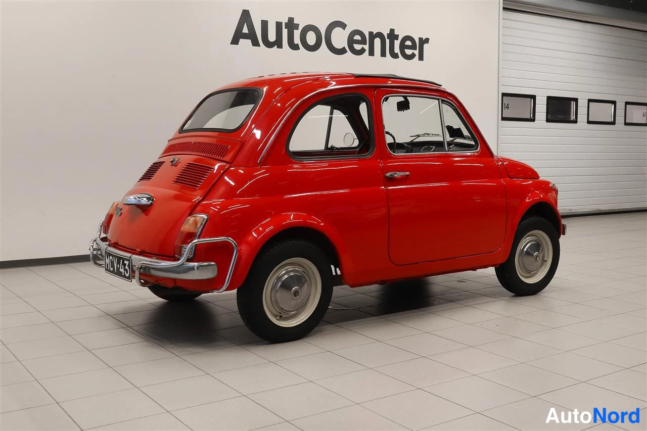 Takaviisto: Punaisen Fiat 500 -henkilöauton takakolmasosa sisätiloissa, rekisterikilpi