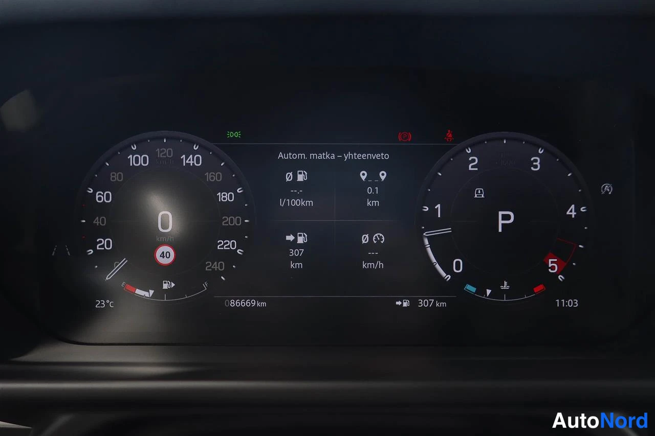 Muu: Auton digitaalinen mittaristo: nopeusmittari näyttää 0 km/h, vaihde P, kokonaislukema 86669 km, ulkolämpötila 23 °C ja kello 11.03. Ruudussa lukee 'Autom. matka