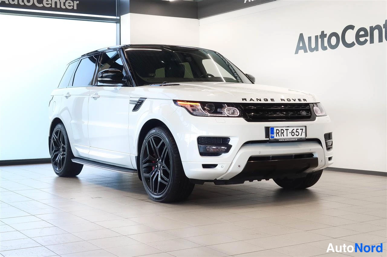 Etuviisto, nokka oikealle: Valkoinen Land Rover Range Rover Sport etukulmasta mustat vanteet Autocenter-tilassa.