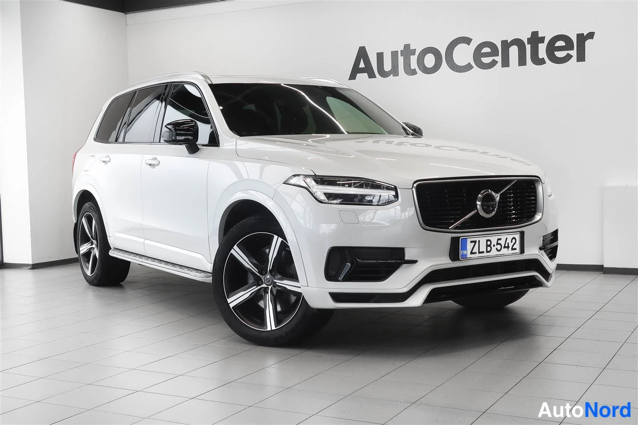 Etuviisto, nokka oikealle: Valkoinen Volvo XC90 etuosa kolmesta neljännekseen kuvattuna näytöllä, rekisteritunnus