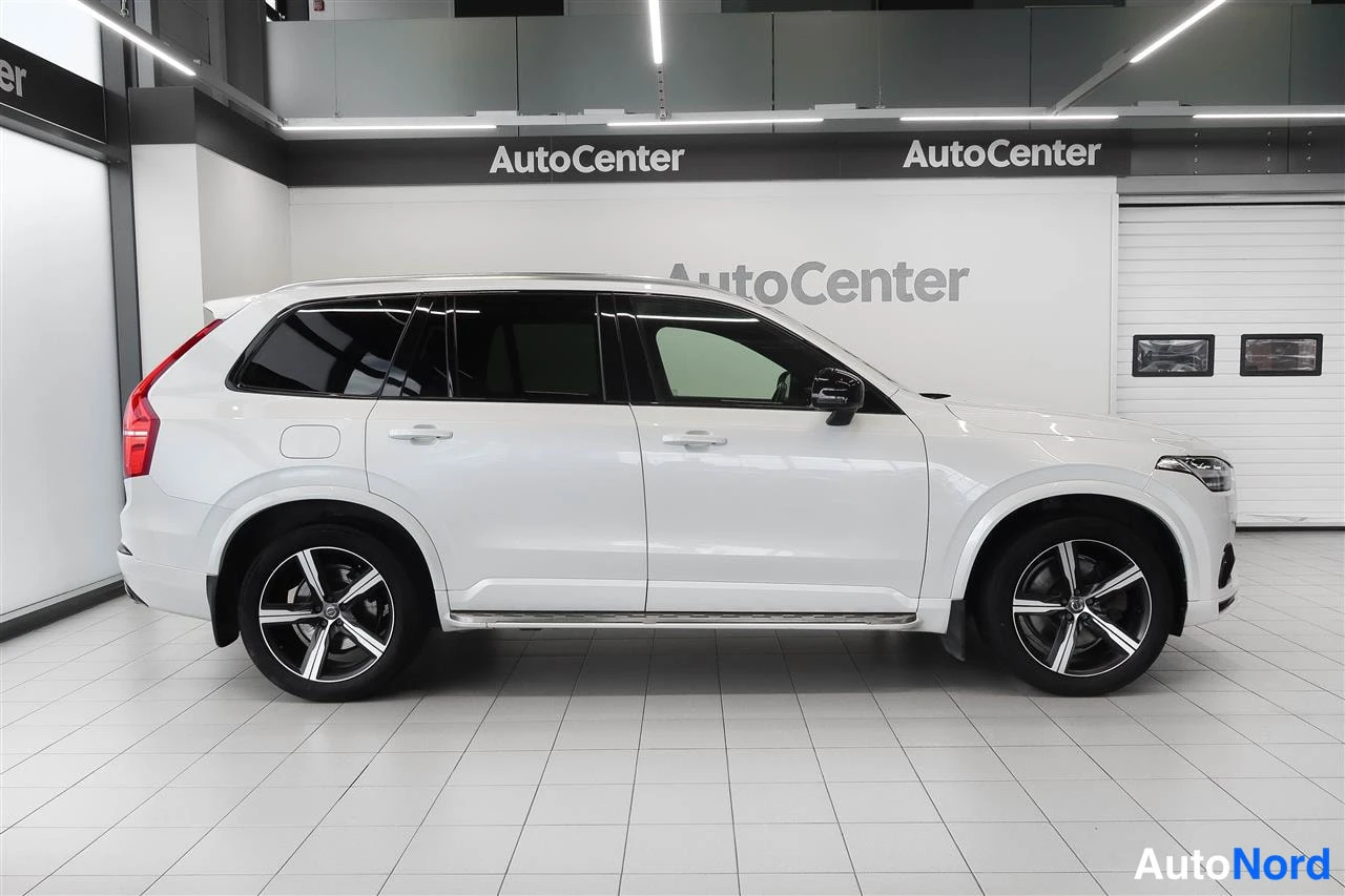 Sivulta: Valkoinen Volvo XC90 sivuprofiilista autosalissa.