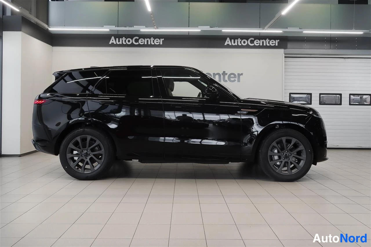 Sivulta: Mustan Land Rover Range Rover Sportin sivuprofiili autosalonissa.