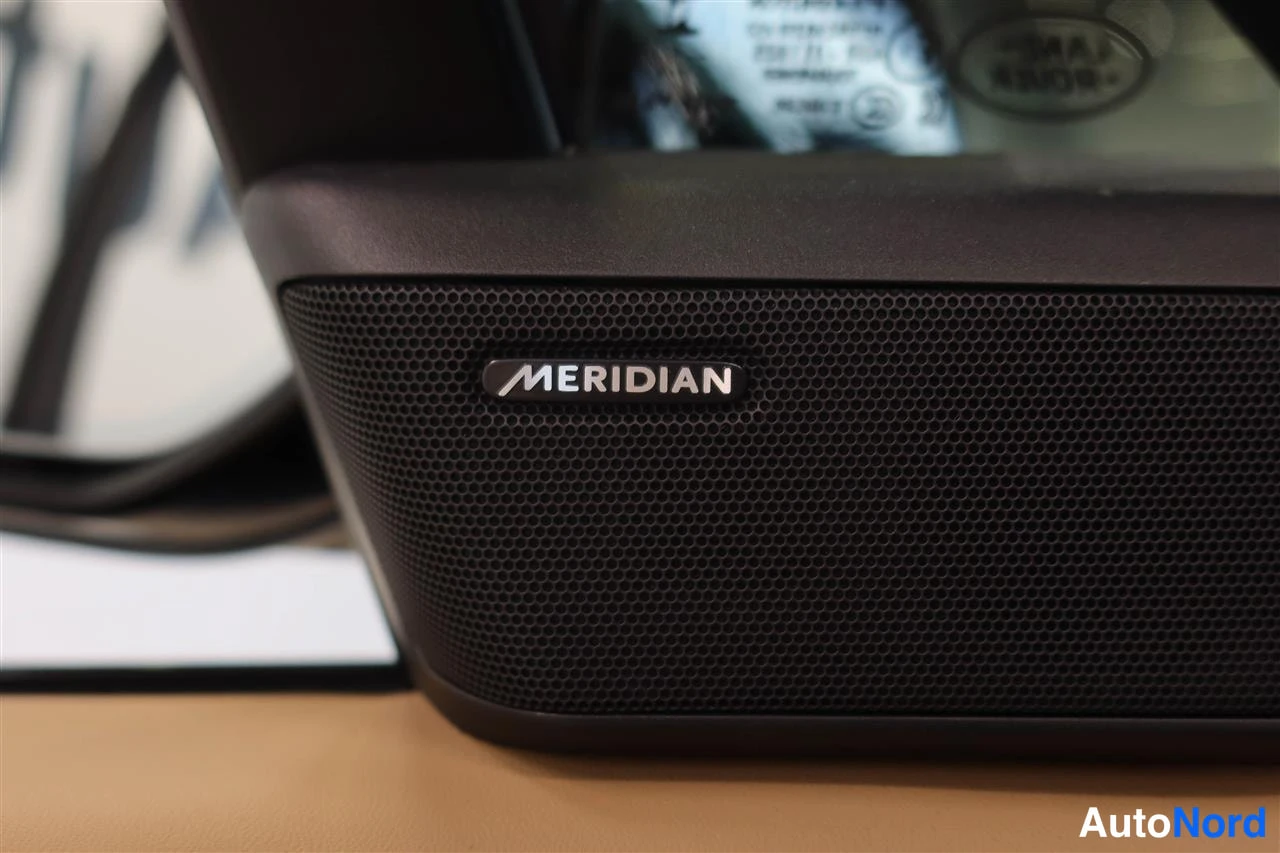 Muu: Nearup close of a door-mounted loudspeaker grille with the Meridian brand label visible.