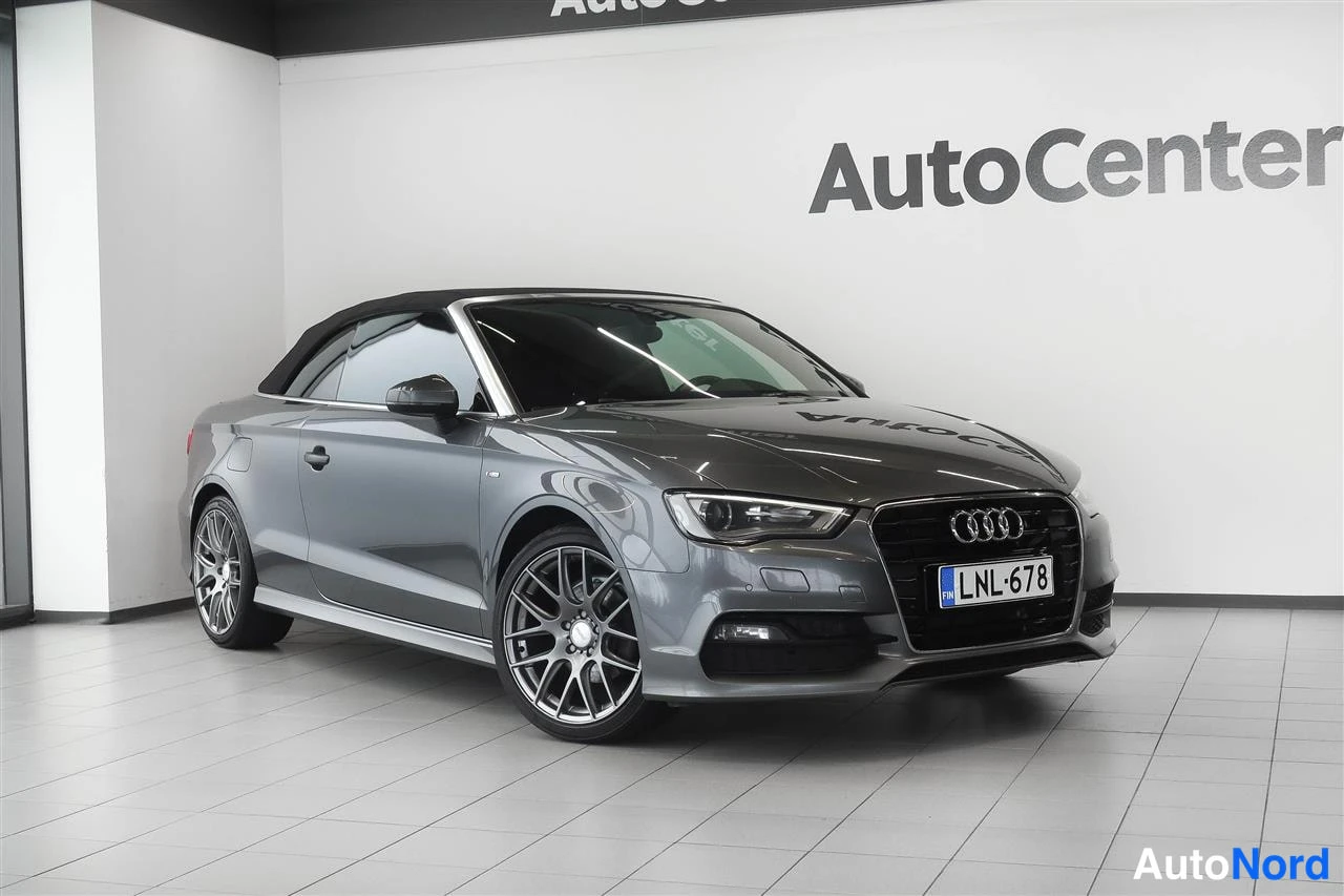 Etuviisto, nokka oikealle: Harmaa Audi A3 Cabriolet etukolmionäkyvällä, katto ylhäällä
