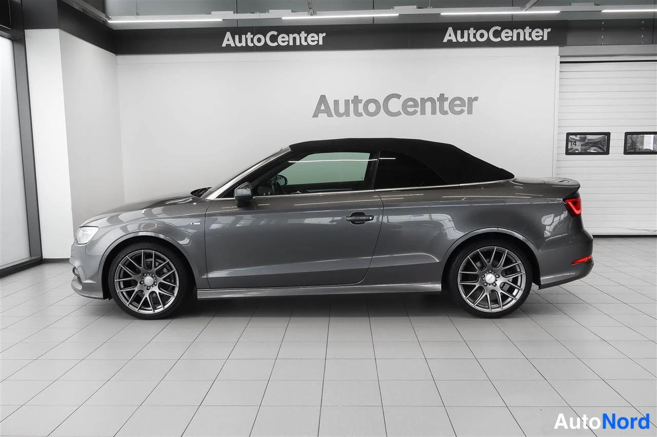 Sivulta: Audi A3 Cabrioletin koko sivuprofiili vasemmalta; kangaskatto ylhäällä, harmaa maalaus ja tummat kevytmetallivanteet.