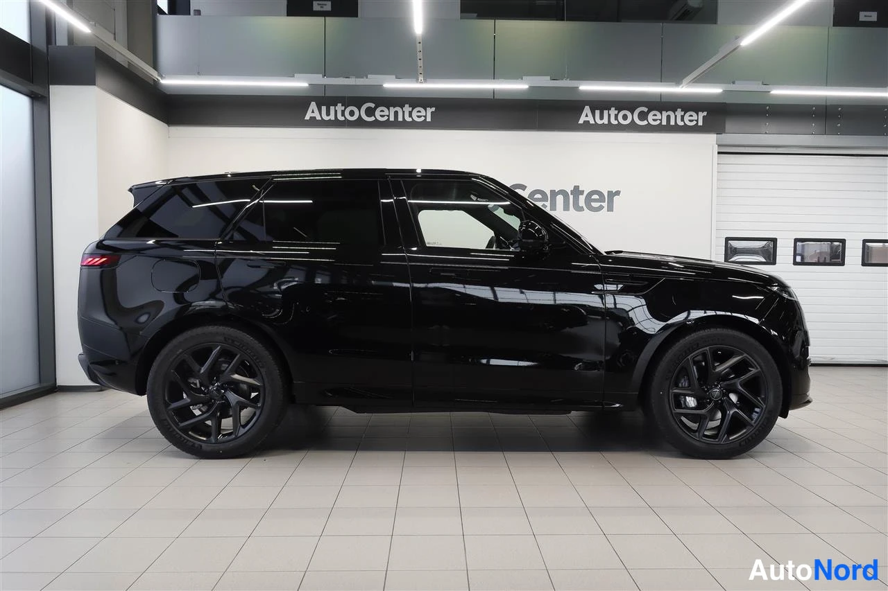 Sivulta: Mustan Land Rover Range Rover Sportin sivunäkymä näkyvällä sisätiloissa AutoCenter-taustalla.