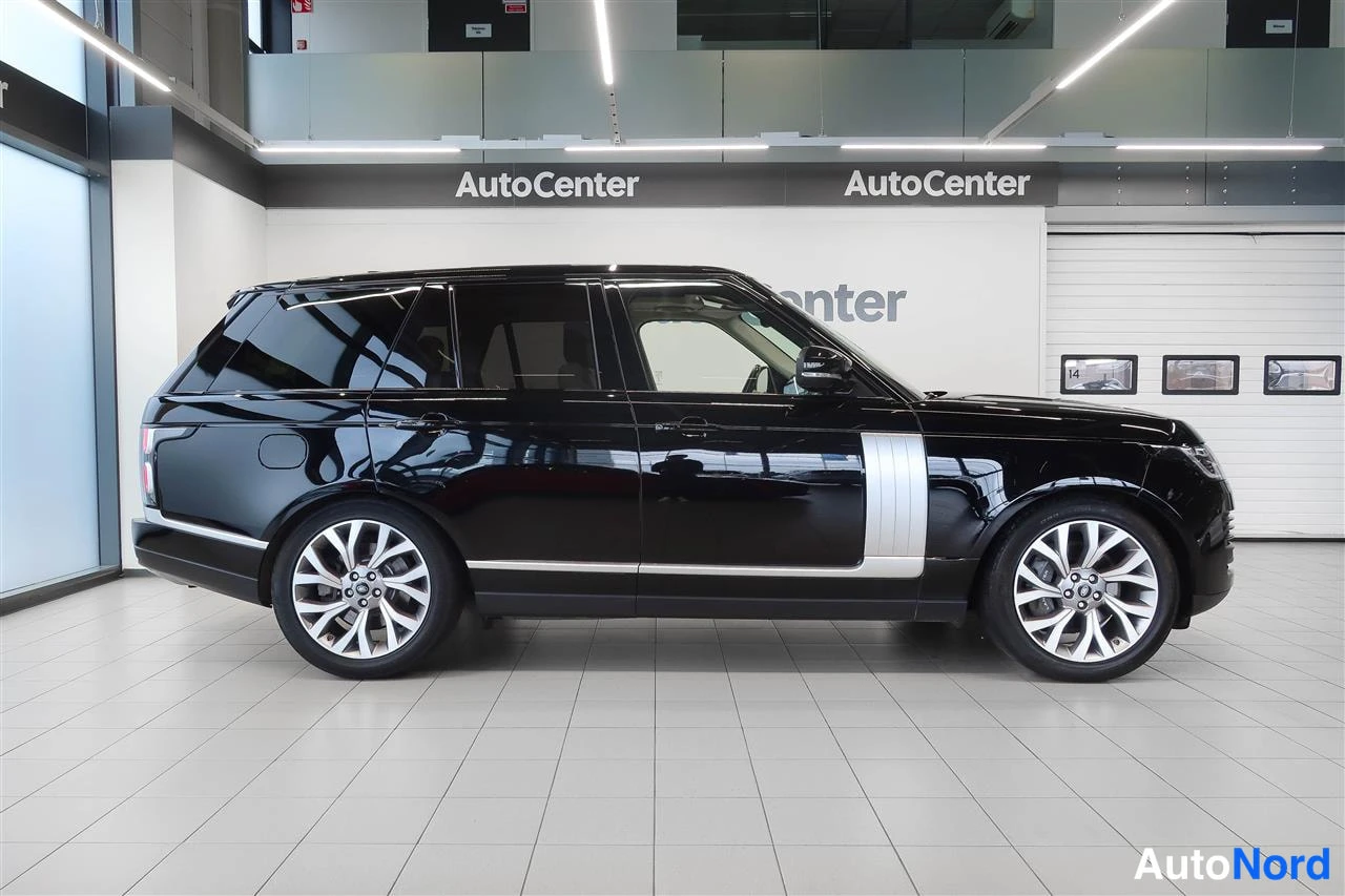 Etuviisto, nokka oikealle: Musta Land Rover Range Rover -maastauto sivulta autonäyttelytilassa, keulakulma näkyvissä.
