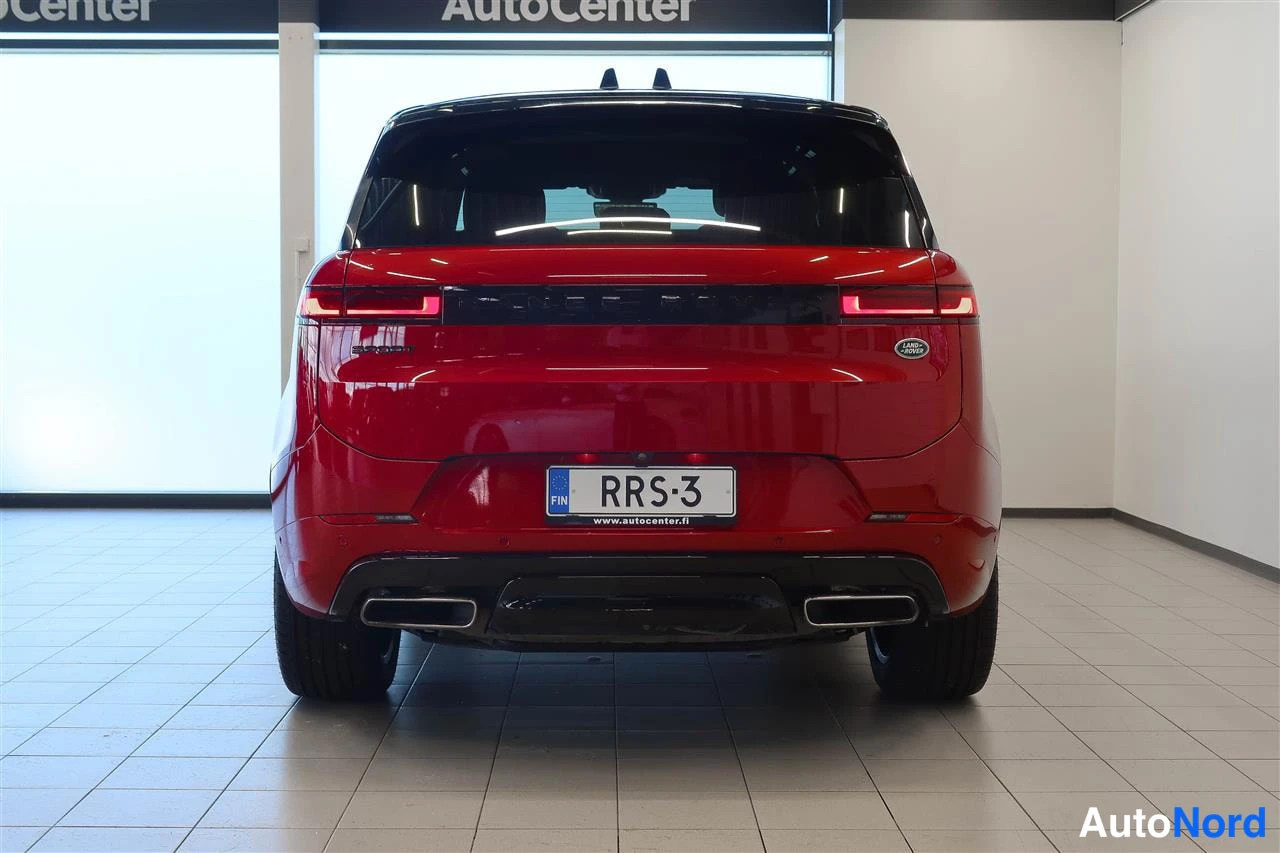 Takaa: Punainen Land Rover Range Rover Sport suoraan takaa kuvattuna; rekisterikilpi, takavalot ja kaksiosaiset pakoputkenpäät näkyvät.