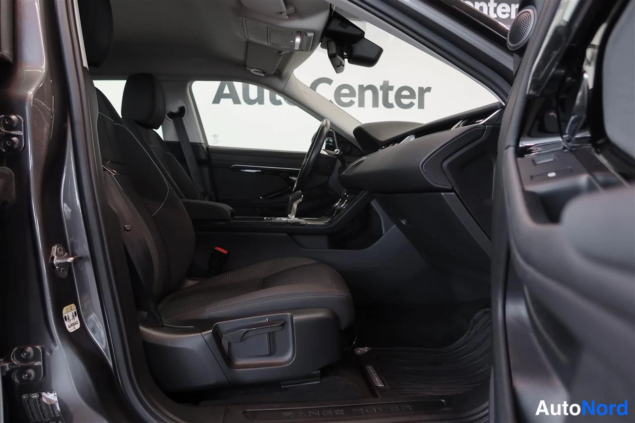 Edestä: Autojen sisätilat vasemmalta: kuljettajan istuin ja kojelauta, ovista näkyy Auto Center -tausta.