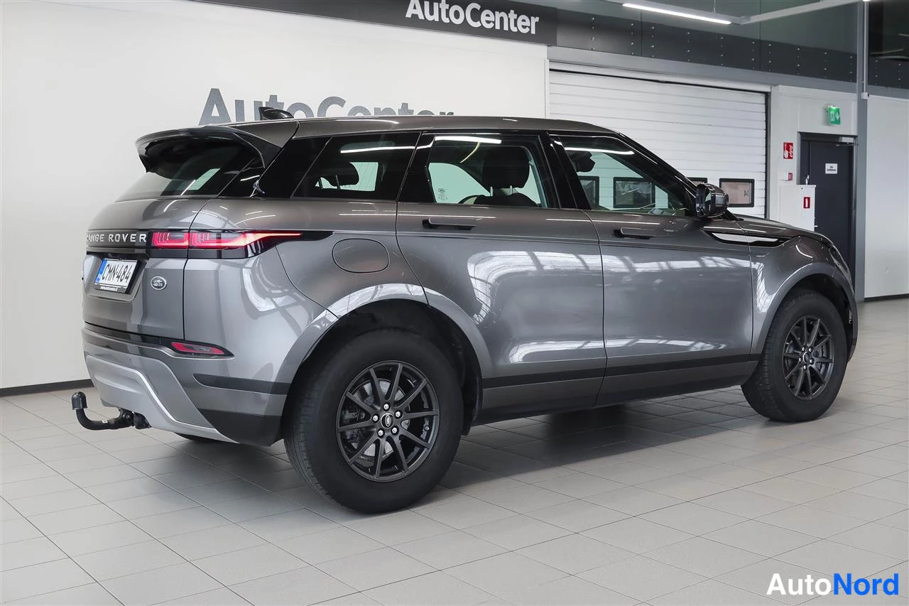 Takaviisto: Land Rover Range Rover Evoquen takakulma kuvattuna vasemmalta; tummanharmaa korimalli, kevytmetallivanteet ja vetokoulu näkyvät showroomissa.