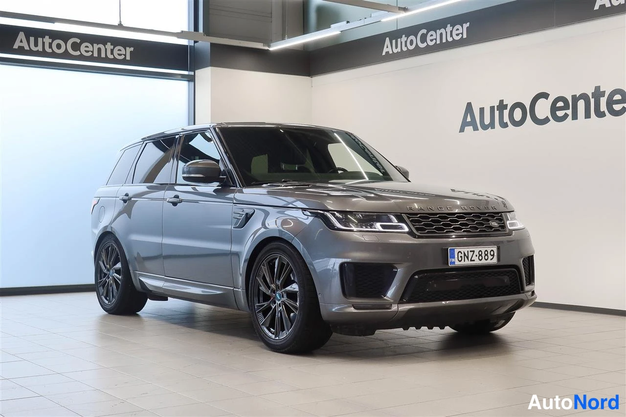 Etuviisto, nokka oikealle: Land Rover Range Rover Sport -maastoauto etu- ja sivupuoli näkyvässä kuvakulmassa, nokka kuvan oikealla puolella, tummanharmaa kori.