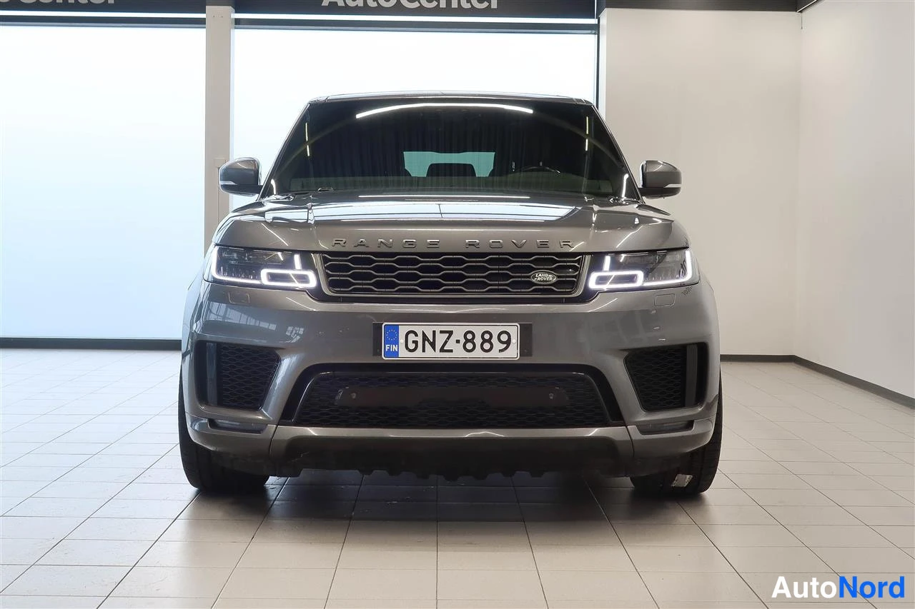 Edestä: Land Rover Range Rover Sport -maastoauto suoraan edestä kuvattuna, tummanharmaa kori, etumoottoritilan kansi ja etupuskuri näkyvissä.