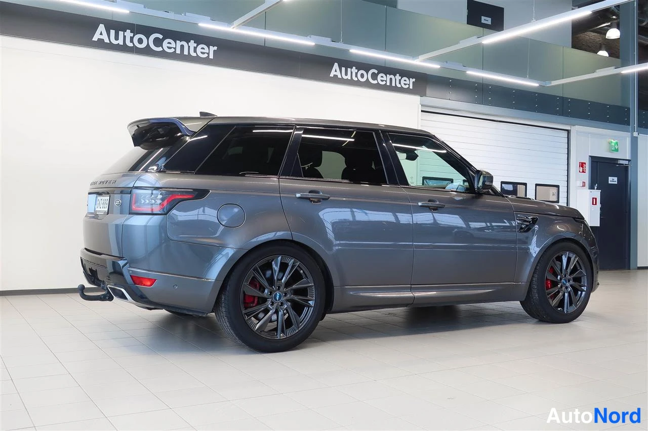 Takaviisto: Land Rover Range Rover Sport takakulmanäkyvissä auton sisätiloissa, tummanharmaa koripelti, mustat kevytmetallivanteet ja punaiset jarrusatulat näkyvät.