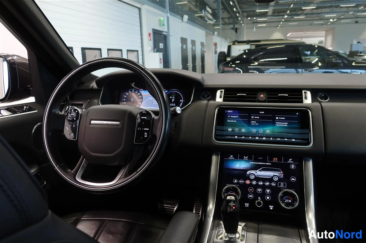 Muu: Range Rover Sportin kojelauta: monitoimiohjauspyörä, digitaalinen mittaristo, laaja kosketusnäyttö ja alapisteenä pyörivä vaihteenvalitsin.