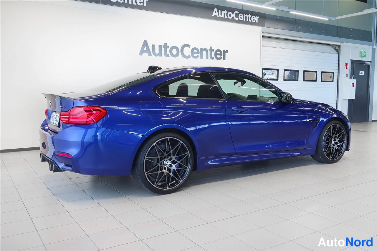 Takaviisto: Sininen BMW M4 -coupé takaviistosta kuvattuna autotallissa.