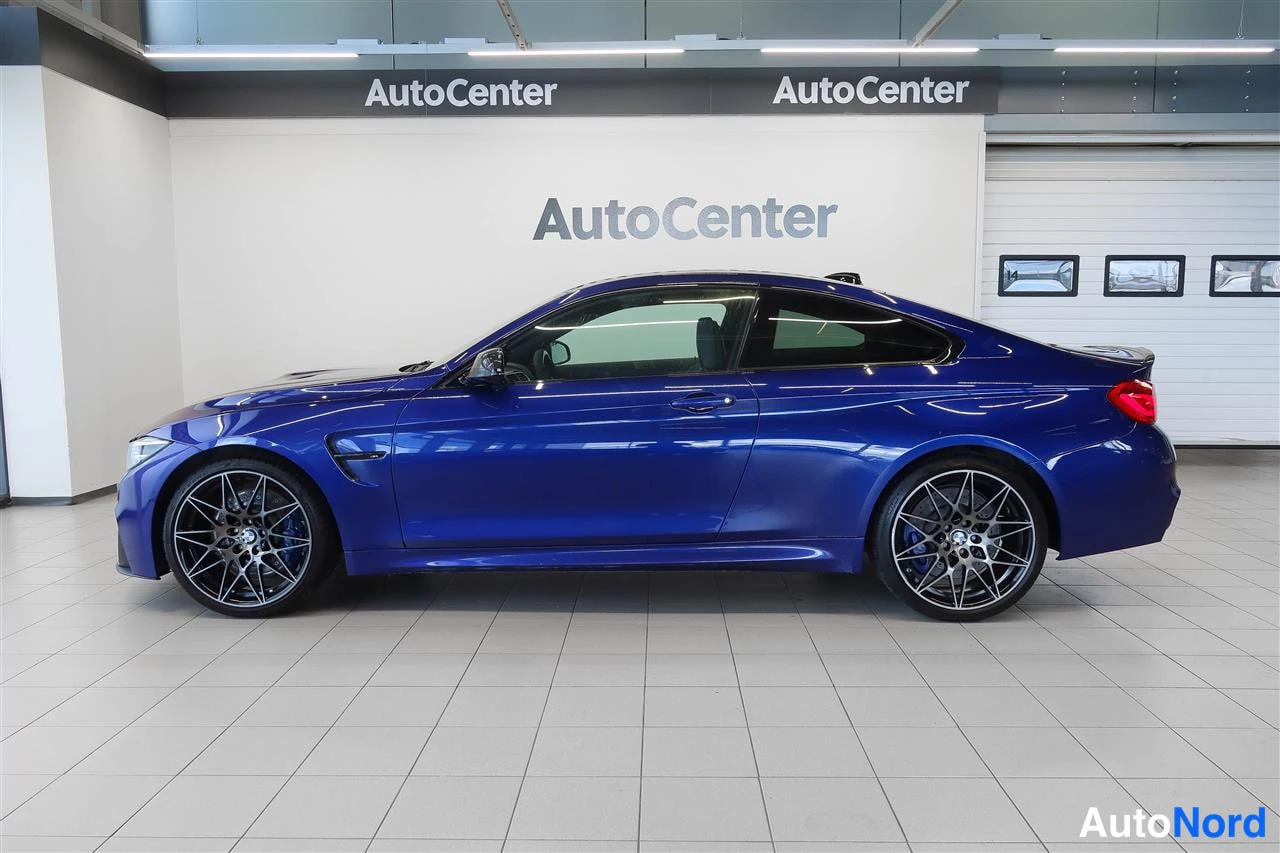 Sivulta: Sivukuva tummansinisestä BMW Coupéstä AutoCenter-hallissa.