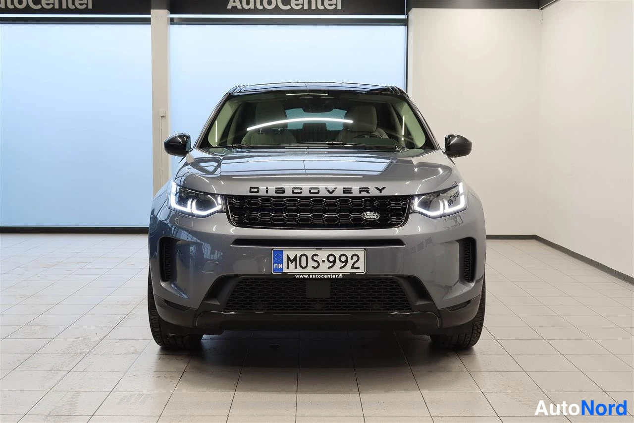 Edestä: Land Rover Discovery Sportin etunäkymä, DISCOVERY-teksti keulassa, rekisterikilpi.