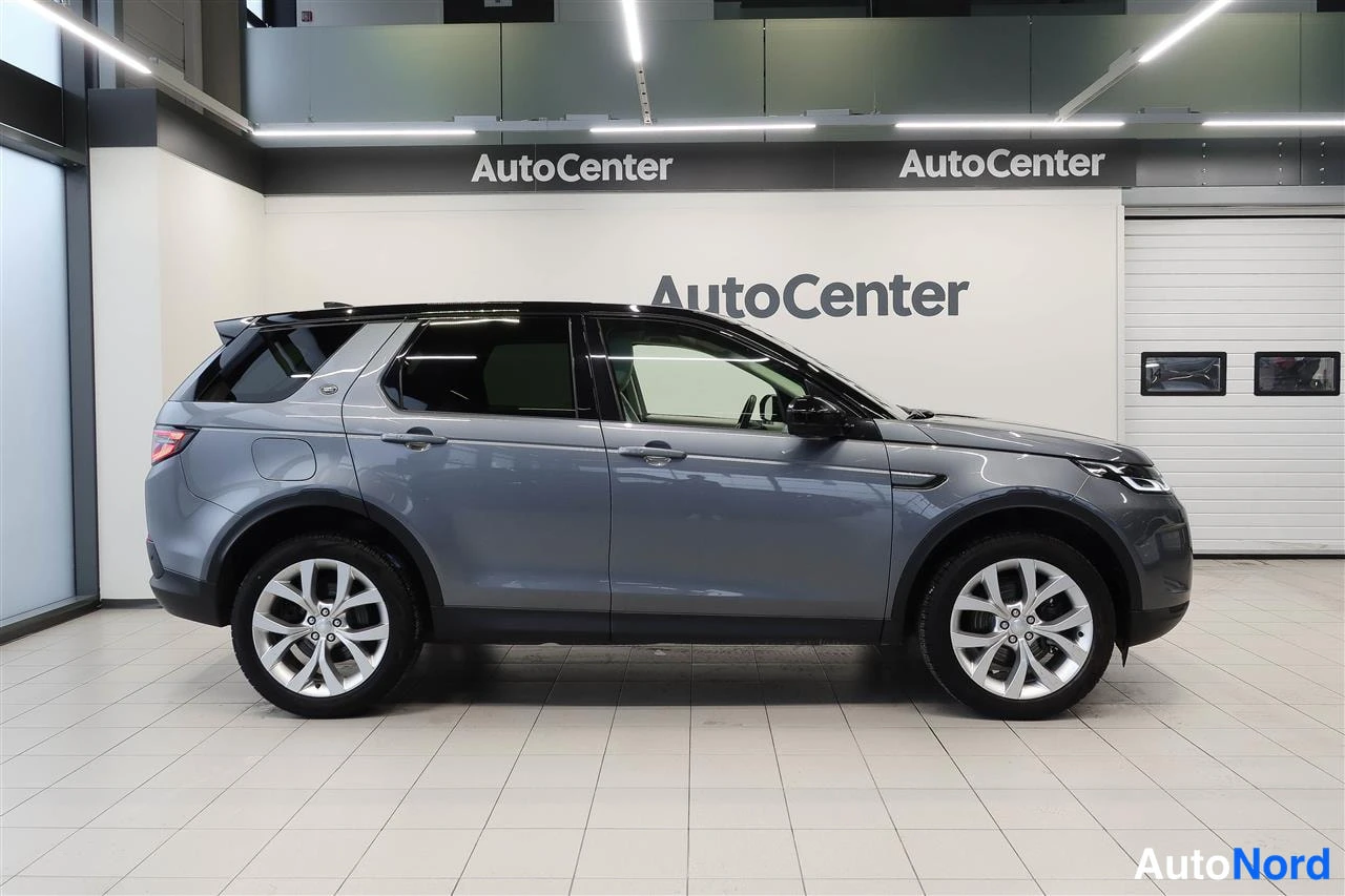 Sivulta: Land Rover Discovery Sportin sivunäkymä oikealta, harmaa kori, tummat ikkunat.