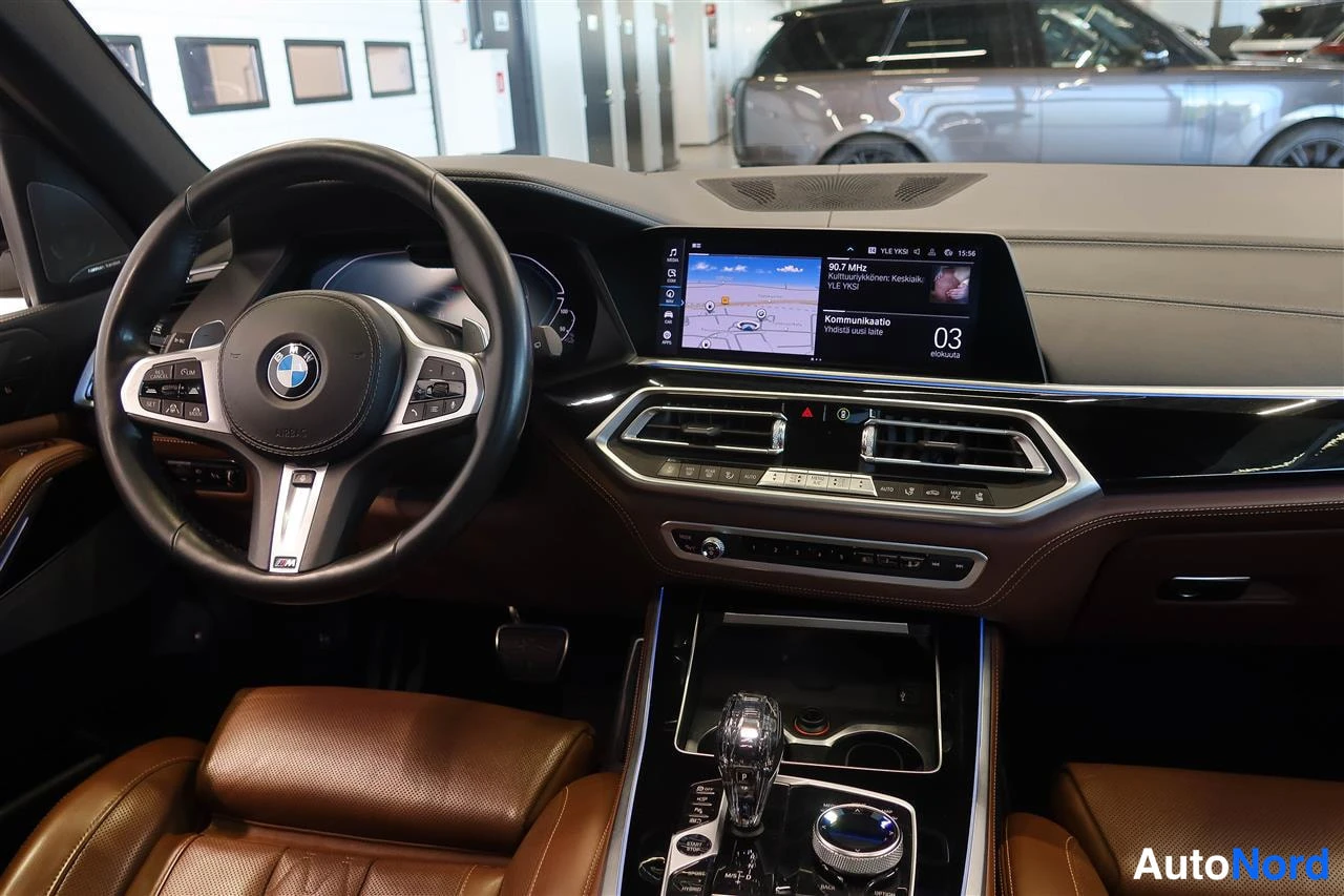 Muu: Kuljettajan puolen kojelauta: BMW-ohjauspyörä, kosketusnäyttö karttaan, ilmastointiaukot ja automaattivaihteen valitsin.