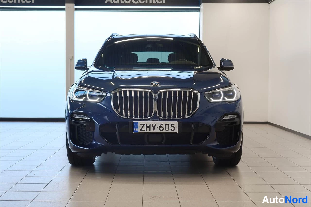 Edestä: BMW X5:n etunäkymä sisätiloissa, tummansininen, rekisteritunnus.