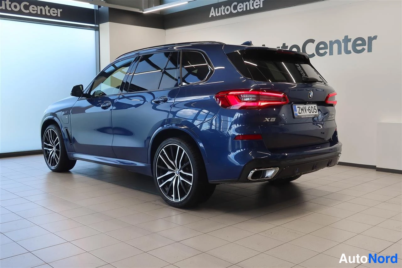 Takaviisto: Sininen BMW X5 takaa kolmasosavinkkulasta kuvattuna autokeskuksen tiloissa