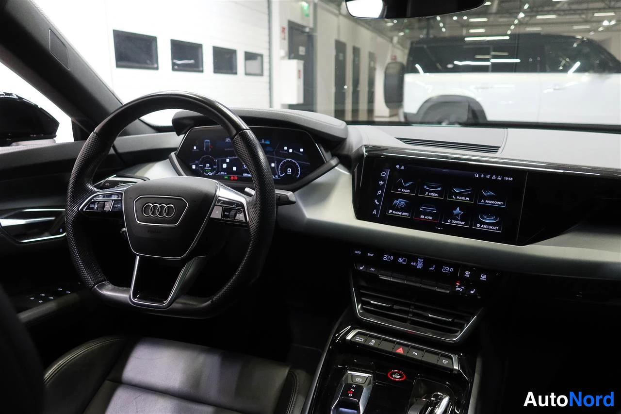 Muu: Ohjaamo vasemmalta: Audi-ohjauspyörä, digitaalinen mittaristo ja kosketusnäyttö radio-, media- ja navigointivalikoilla, automaattivaihteen valitsin ja käynnisty