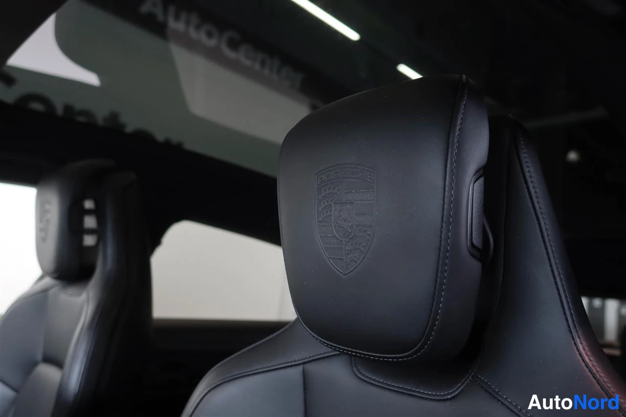 Edestä: Etumatkustajan istuimen nuppipäinen pääntuki, jossa on Porsche-kilpiompeleet; taustalla kuljettajan istuimen nuppipäinen pääntuki.