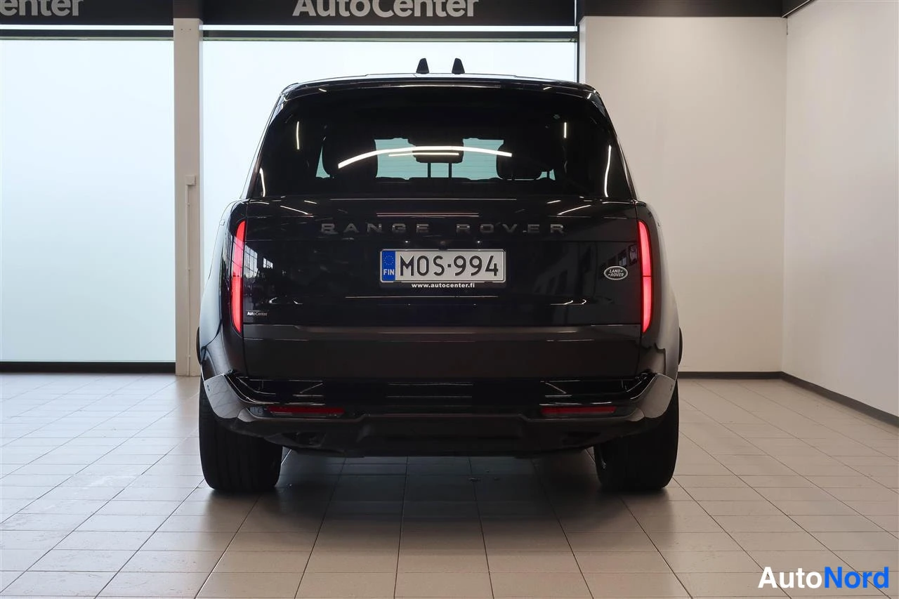 Takaa: Mustan maasturin takaa 45-värittömästi kuvattu takapää: Range Rover -teksti, rekisteritunnus ja punaiset takavalot.