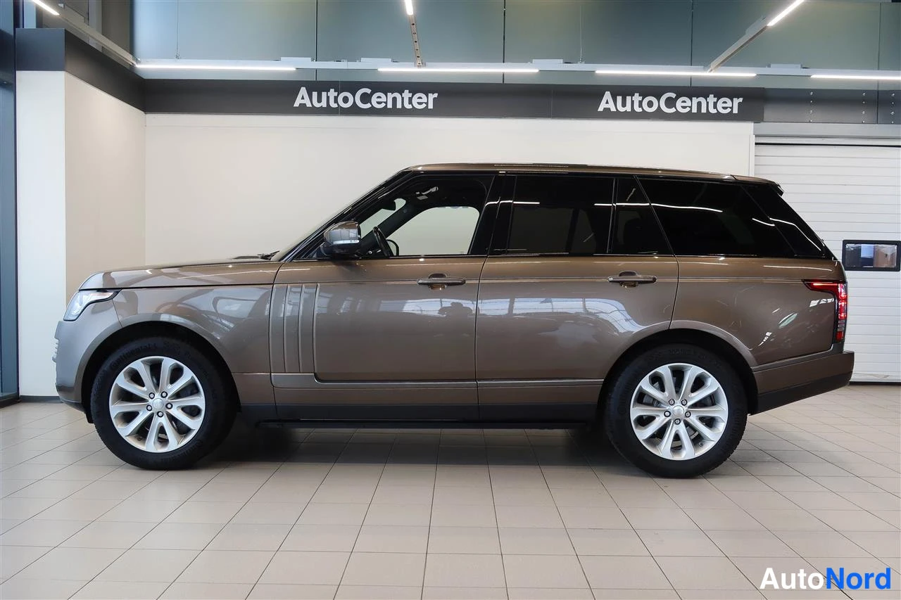 Takaviisto: Sivukulmakuva ruskeahkosta Land Rover Range Roverista autonäyttelytilassa.